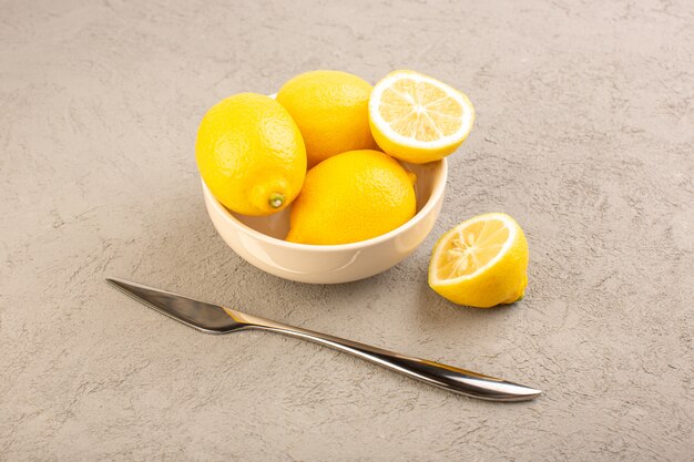 Une vue de dessus des citrons frais aigre mûr entier moelleux agrumes tropical vitamine jaune sur le bureau de la crème