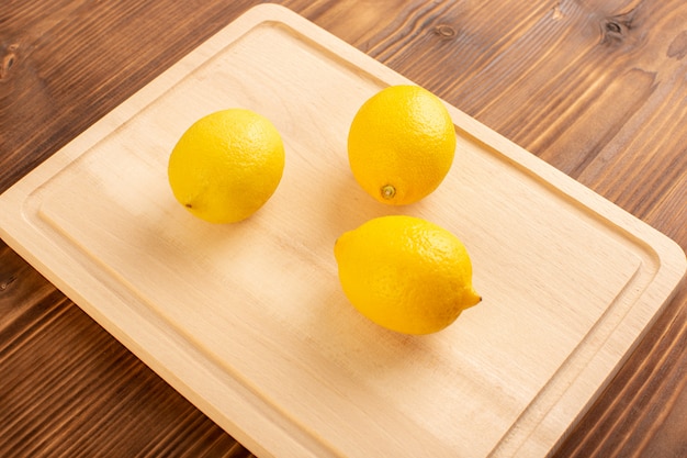 Une vue de dessus des citrons frais aigre mûr mûr juteuse vitamine d'agrumes jaune sur le brun rustique