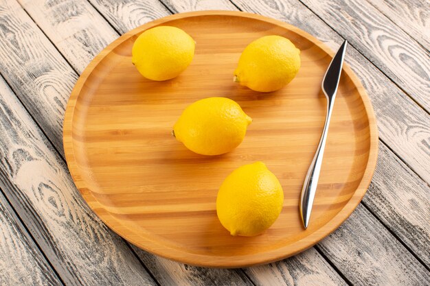 Une vue de dessus des citrons frais aigre mûr mûr juteuse vitamine d'agrumes jaune sur le bureau rustique gris