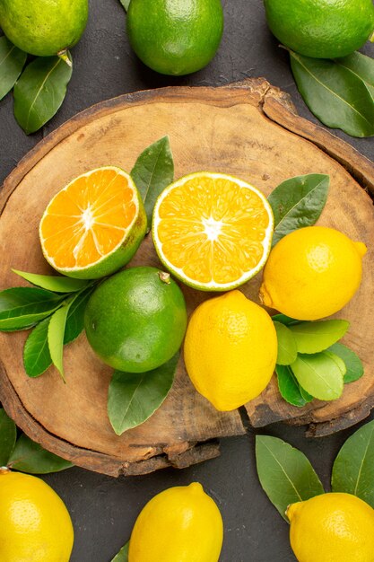 Vue de dessus citrons frais sur la table sombre citron vert fruits aigres agrumes