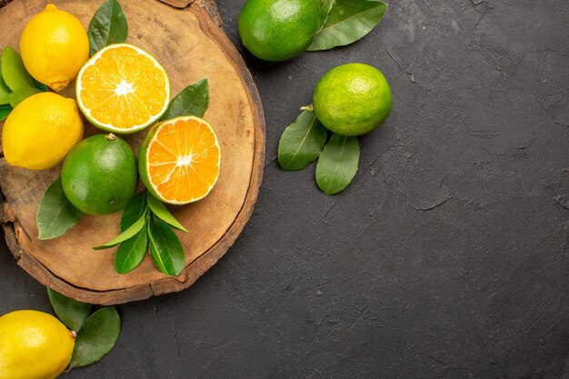 Vue de dessus citrons frais sur la table sombre citron vert fruits aigres agrumes