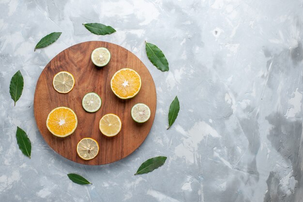 Vue de dessus citrons frais tranchés agrumes juteux sur le bureau léger fruits jus d'agrumes frais aigre