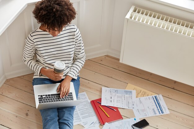 Vue de dessus des claviers des travailleurs distants expérimentés occupés sur un ordinateur portable, calcule les coûts