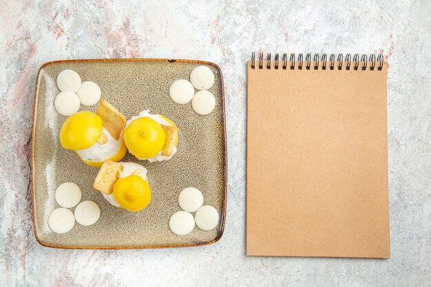 Vue de dessus des cocktails au citron avec des bonbons blancs sur table blanche boire du jus de fruits cocktail