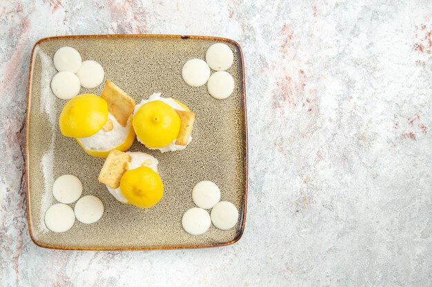 Vue de dessus des cocktails au citron avec des bonbons blancs sur table blanche boire du jus de fruits cocktail