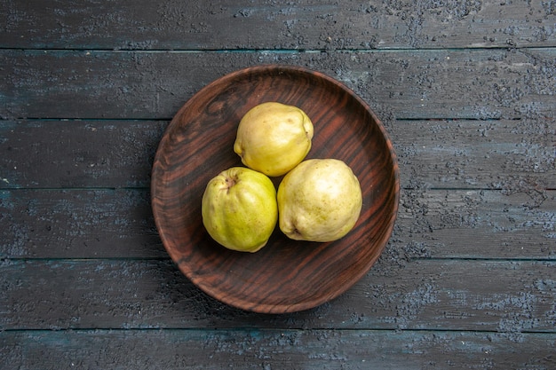 Vue De Dessus Coings Mûrs Frais Fruits Aigres à L'intérieur De La Plaque Sur Un Bureau Rustique Bleu Foncé Plante Fruitière Mûre Fraîche