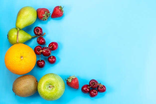 Une vue de dessus de la composition colorée de fruits frais isolé sur bleu, couleur de fruits moelleux