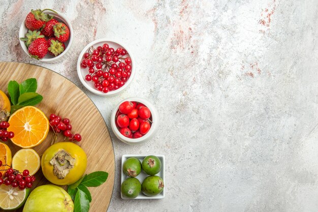 Vue de dessus de la composition des fruits différents fruits sur la table blanche berry fruits frais mûrs