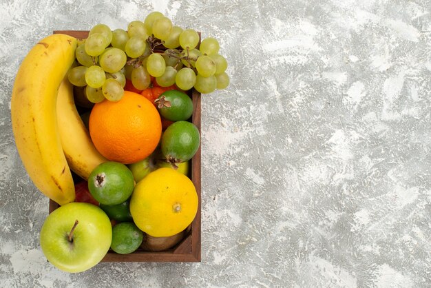 Vue de dessus composition de fruits frais bananes raisins et feijoa sur fond blanc fruits doux vitamine santé frais