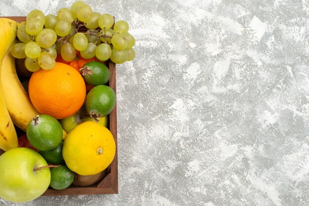 Vue de dessus composition de fruits frais bananes raisins et feijoa sur fond blanc fruits doux vitamine santé frais
