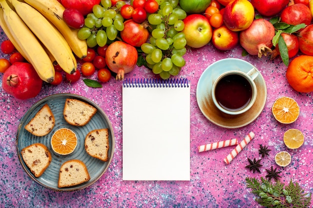 Vue De Dessus De La Composition De Fruits Frais Fruits Colorés Avec De Délicieux Gâteaux En Tranches Et Du Thé Sur Le Bureau Rose