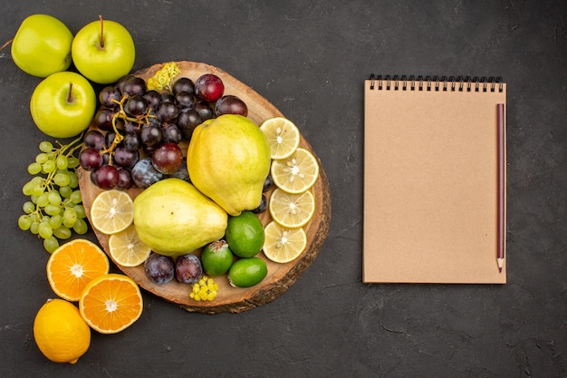 Photo gratuite vue de dessus composition de fruits frais fruits moelleux et mûrs sur fond sombre fruits mûrs moelleux santé frais