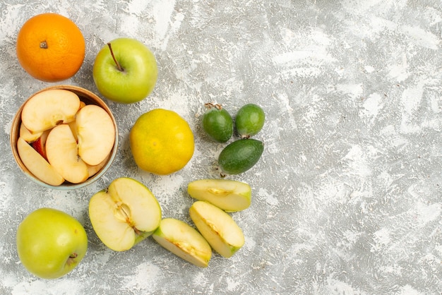 Vue de dessus composition de fruits frais pommes feijoa et autres fruits sur fond blanc fruits frais moelleux couleur mûre vitamine santé