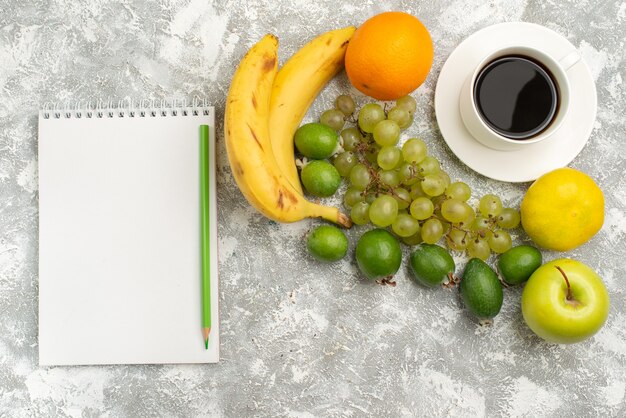 Vue de dessus de la composition de fruits frais pommes raisins et bananes avec du café sur fond blanc fruits frais moelleux couleur mûre vitamine