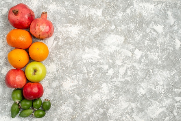 Vue de dessus de la composition de fruits mandarines et pommes feijoa sur fond blanc vitamine fruits mûrs mûrs