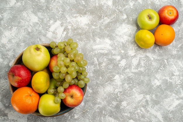 Vue de dessus de la composition des fruits raisins mandarines et pommes sur fond blanc fruits mûrs vitamine douce douce