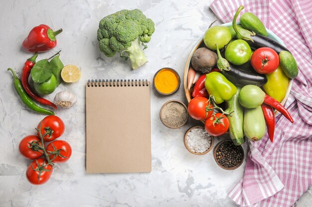 Vue de dessus de la composition de légumes frais à l'intérieur de la plaque sur fond blanc