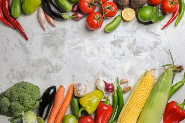 Vue de dessus de la composition de légumes frais sur sol blanc