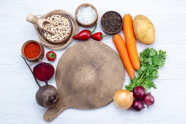 Vue de dessus de la composition végétale avec des légumes frais haricots crus carottes et pommes de terre sur le bureau blanc salade de légumes repas alimentaire