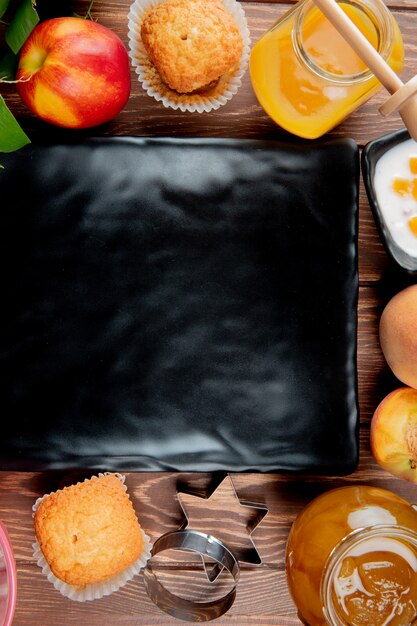 Vue de dessus de la confiture de pêches et de fromage cottage cupcake avec plaque au centre sur la surface en bois