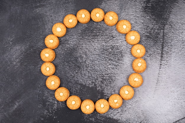 Vue de dessus des cookies disposés en cercle sur une surface sombre