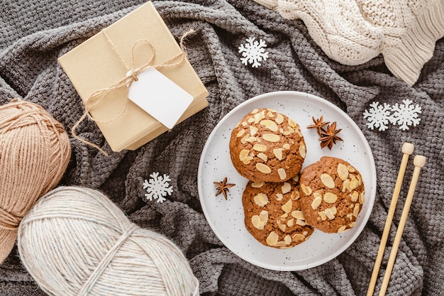 Photo gratuite vue de dessus des cookies, du fil et une boîte-cadeau sur une couverture