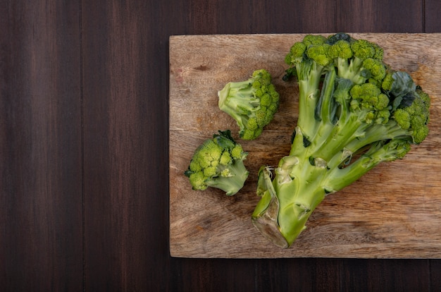 Photo gratuite vue de dessus copie espace brocoli sur planche à découper sur fond de bois