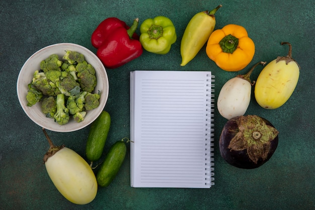 Vue de dessus copie espace copybook avec concombres et poivrons et brocoli sur fond vert