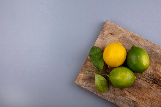 Vue de dessus copie espace limes au citron sur une planche à découper sur fond gris