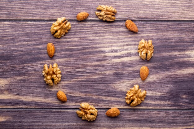 Vue de dessus copie espace noix pelées aux amandes pelées en forme de cercle sur un fond en bois