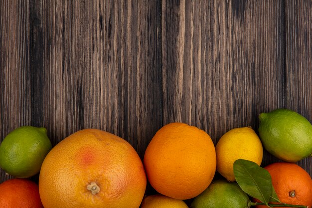 Vue de dessus copie espace pamplemousse avec des oranges, des citrons et des limes sur fond de bois