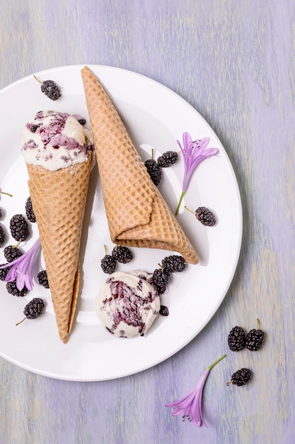 Photo gratuite vue de dessus des cornets de crème glacée avec des mûres et des fleurs