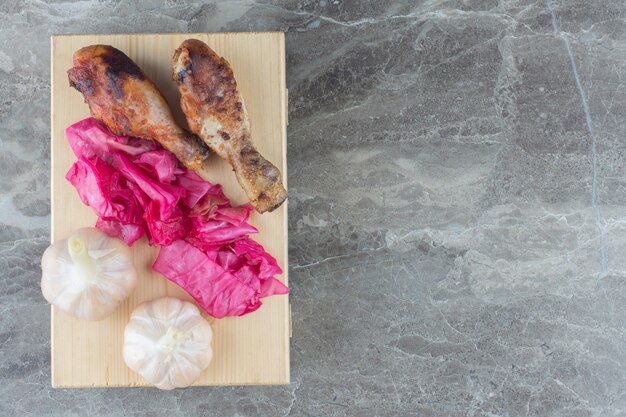 Vue de dessus des cornichons faits maison et des cuisses de poulet grillées.