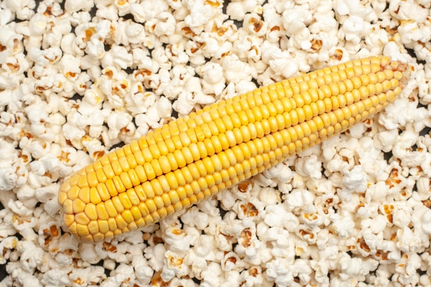 Vue de dessus des cors jaunes frais avec du pop-corn sur fond sombre