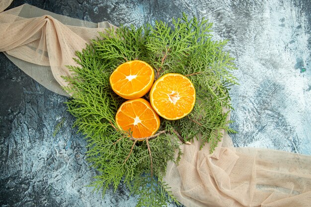 Vue de dessus couper les branches de pin oranges sur châle beige sur l'espace libre de surface grise
