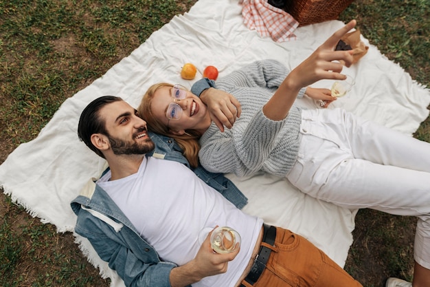 Vue de dessus couple ayant un pique-nique ensemble à l'extérieur