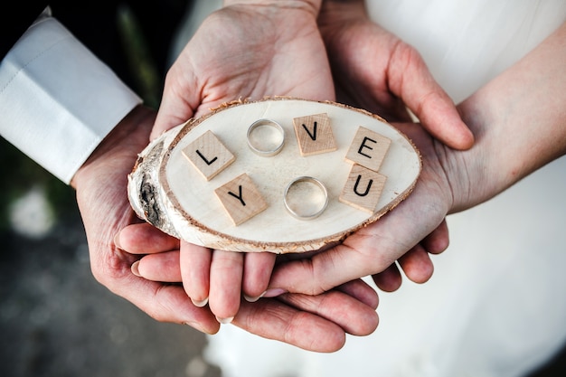 Vue de dessus couple tenant les anneaux de mariage