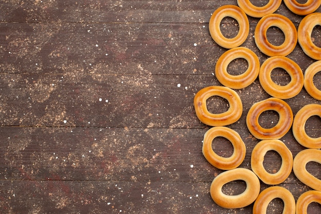 Vue de dessus craquelins ronds sucrés séchés et collations savoureuses sur brun, biscuit biscuit boire du lait