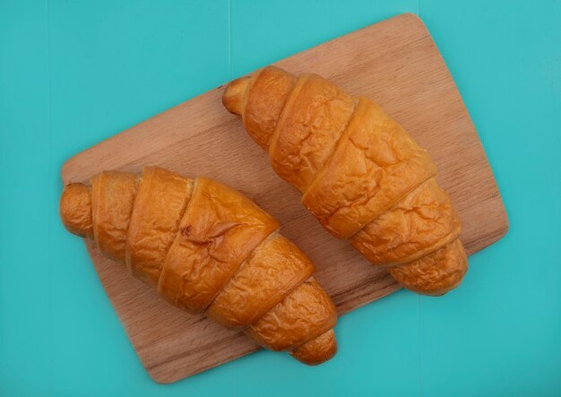 Vue de dessus des croissants sur une planche à découper sur fond bleu