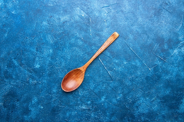 Photo gratuite vue de dessus cuillère en bois sur table bleue avec espace copie