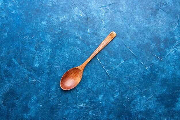 Vue de dessus cuillère en bois sur table bleue avec espace copie