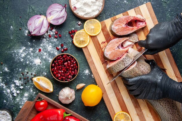 Vue de dessus cuisinier coupant du poisson cru sur une planche à découper un bol de farine de citron sur une table