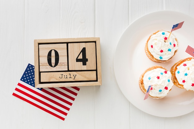 Photo gratuite vue de dessus des cupcakes sur plaque avec drapeaux américains et date