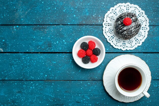 Vue de dessus délicieuse boule de chocolat avec une tasse de thé sur le bureau rustique bleu gâteau au thé biscuit biscuit sucré