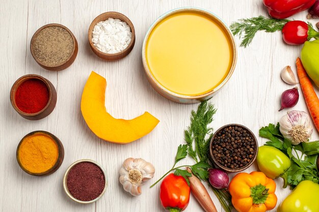 Vue de dessus délicieuse crème de soupe à la citrouille texturée avec des légumes sur un bureau blanc repas de sauce à soupe mûre