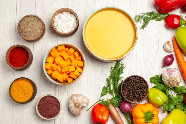 Vue de dessus délicieuse crème de soupe à la citrouille texturée avec des légumes sur un bureau blanc repas de sauce à soupe mûre