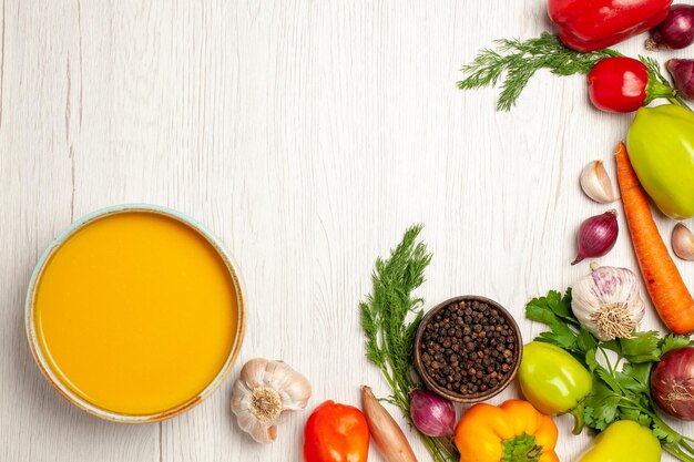 Vue de dessus délicieuse crème de soupe à la citrouille texturée avec des légumes sur un bureau blanc repas de sauce à soupe mûre