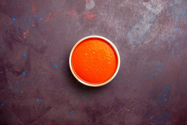 Vue de dessus délicieuse crème de soupe à la tomate texturée à base de tomates fraîches sur fond sombre sauce plat à soupe repas tomate