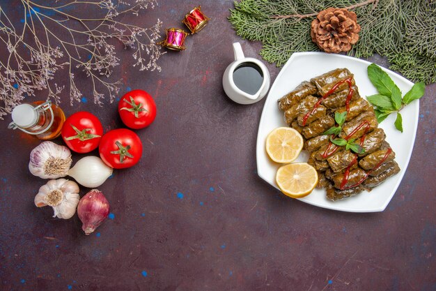 Vue de dessus délicieuse feuille dolma avec des tranches de citron sur un bureau sombre plat de viande feuille dîner repas nourriture