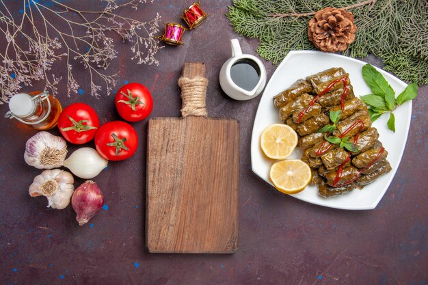 Vue de dessus délicieuse feuille dolma avec des tranches de citron sur un sol sombre plat de viande feuille dîner repas nourriture